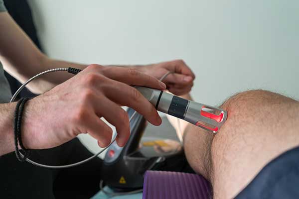 A cold laser therapy tool at use on a patient’s knee