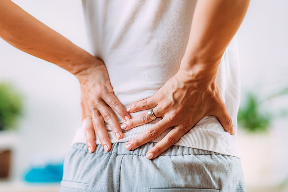 Person with hands on back.