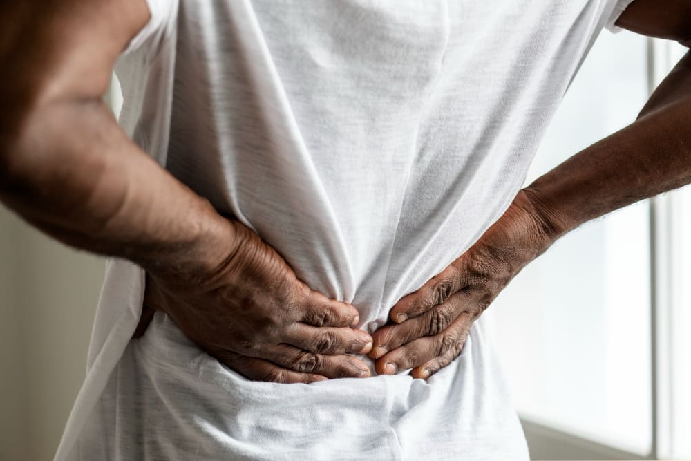 Person holding lower back in pain.