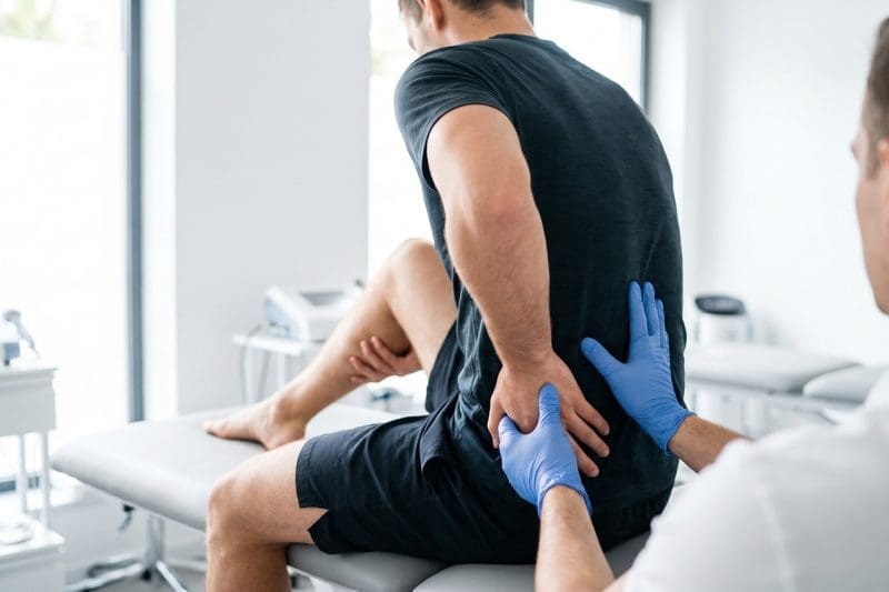 A chiropractor examining an athlete.
